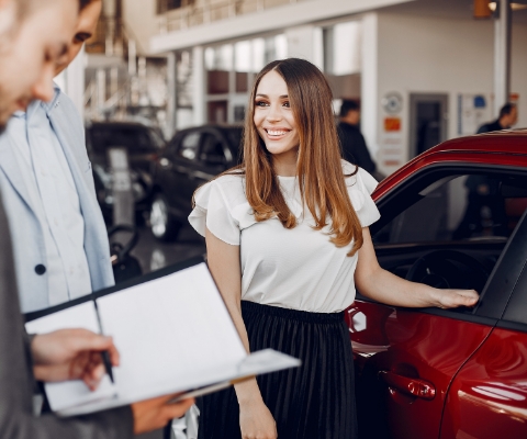 女性が車の横で笑顔で話す